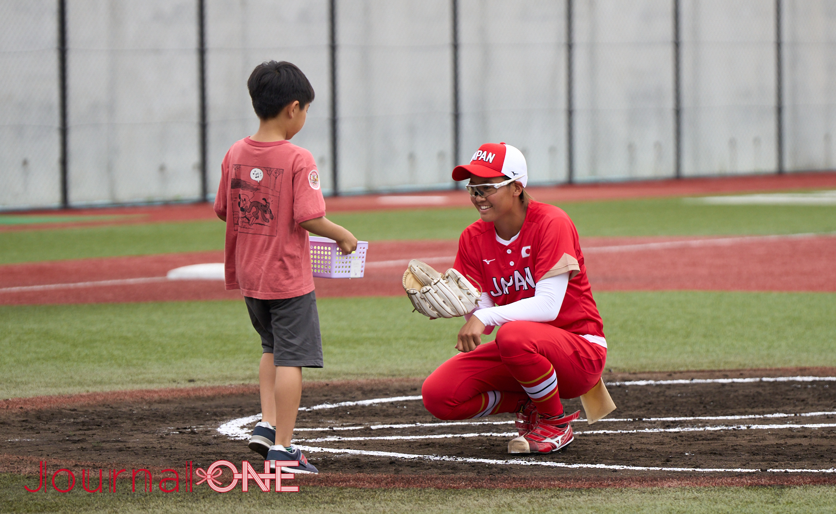 JournalｰONE | 女子ソフトボール日本代表とJDリーグ選抜が能登半島地震復興チャリティマッチ 子どもから試合球を受け取る後藤希友投手（トヨタ）-Journal-ONE撮影